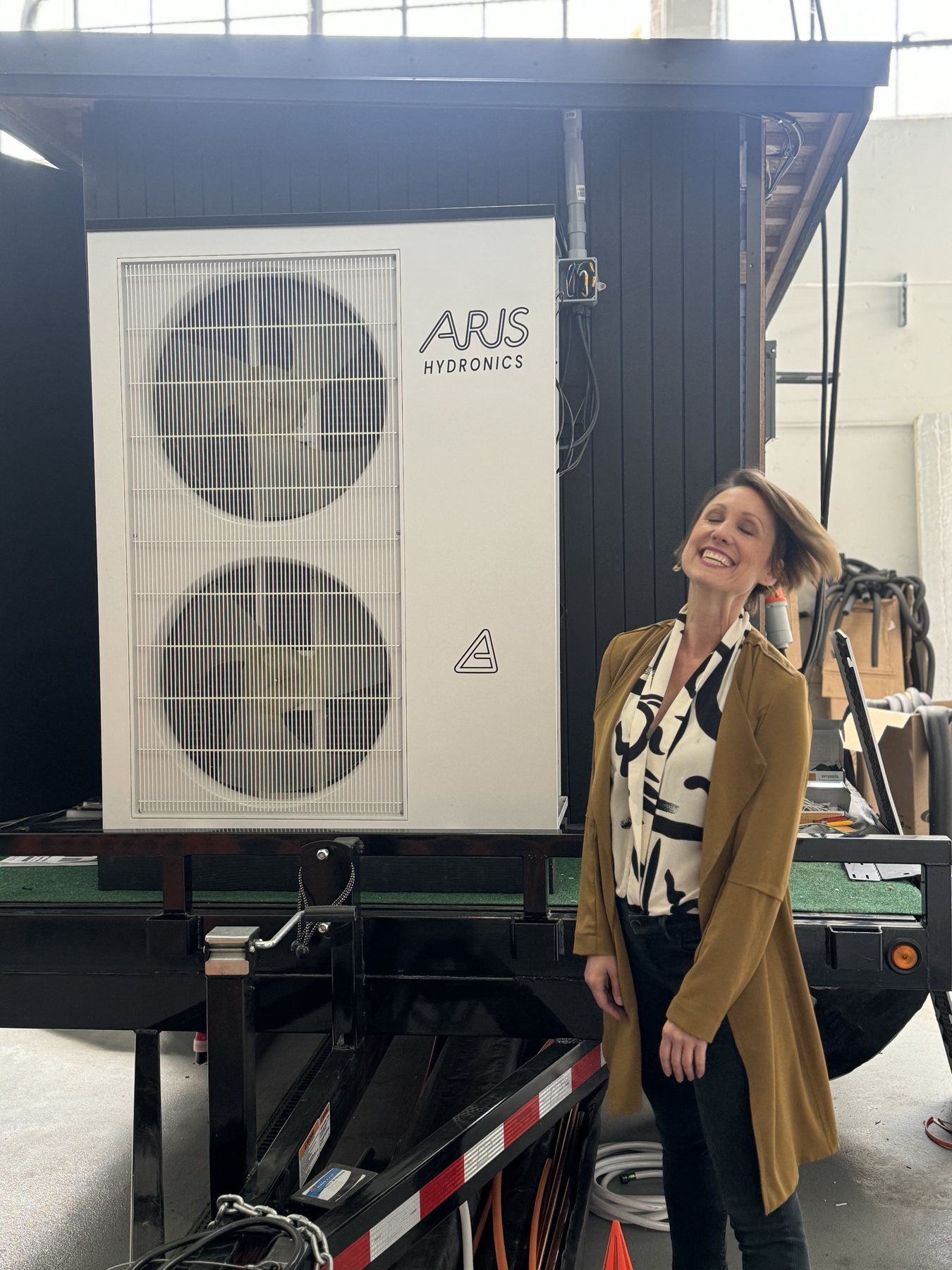 Helene Cornell beside an Aris Hydronics heat pump unit